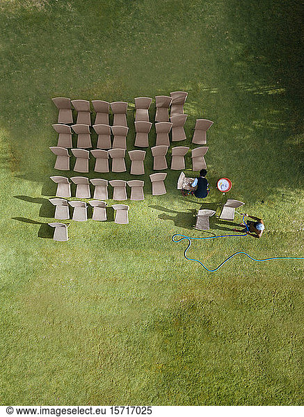 Indonesia  West Nusa Tenggara  Sumbawa  Aerial view of two young men washing chairs with garden hose