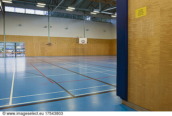 Indoor basketball court  epmpty gym  Sign on wall banning food or drink in gym