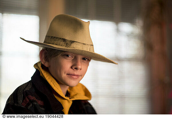 Indoor portrait of boy wearing large hold hat