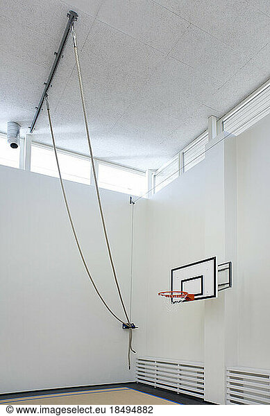 Indoor sports hall in a school  climbing ropes attached to the ceiling.