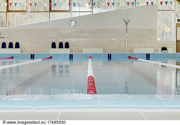Indoor swimming pool  red and white dividers in swim lanes  surface view.