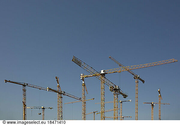 Industrial cranes against clear sky