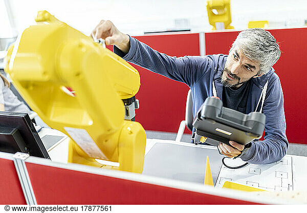 Industrial engineer working at industrial robot using digital control
