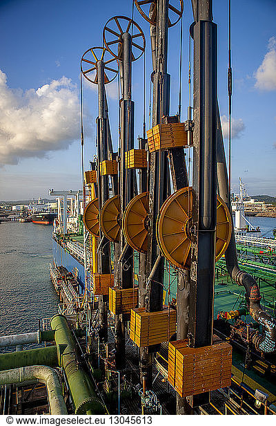Industrial equipment at oil exploration platform against sky in sea