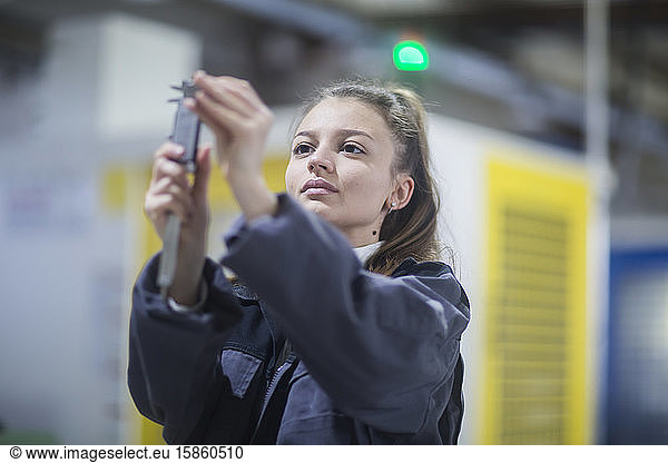 industrial plant with an engineer female controlling a tool