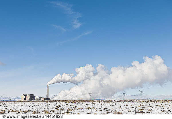 Industriekomplex und Schneelandschaft unter blauem Himmel