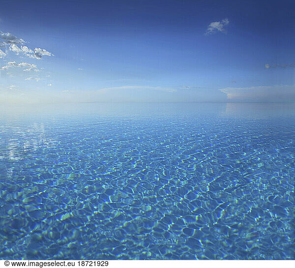 Infinity pool beneath a clear blue sky at a hotel resort in the Philippines.