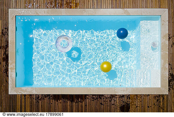 Inflatable ring and ball floating in swimming pool