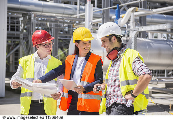 Ingenieur und Arbeiter bei einer Besprechung auf dem Gelände eines geothermischen Kraftwerks