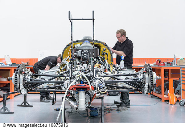 Ingenieure konstruieren Rennwagen in Rennwagenfabrik