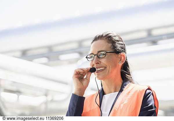 Ingenieurin mit Headset und Lächeln in einem geothermischen Kraftwerk