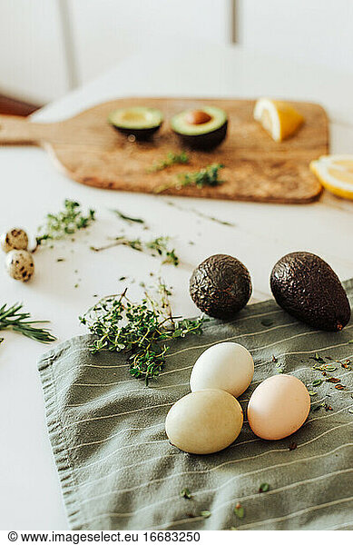 Ingredients for a meal: avocado  eggs  aromatic herbs on a table