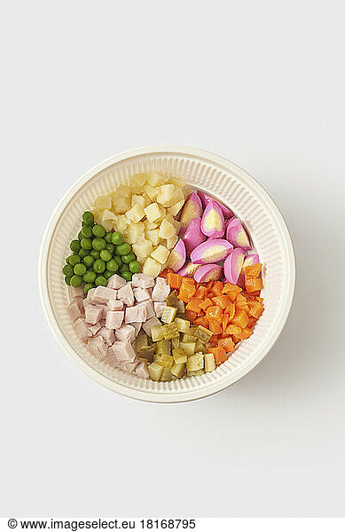 Ingredients for Olivier salad in bowl against white background