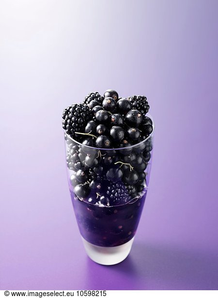 Ingredients in drinking glass for blackcurrant and blackberry fruit juice