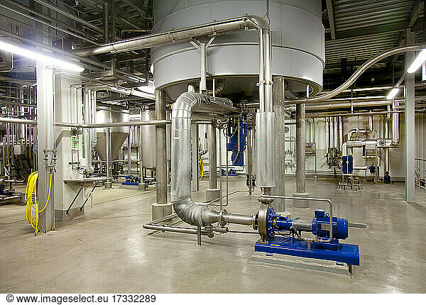 Innenraum einer Brauerei  große Stahltanks für das Bierbrauen mit Metallrohren und Ventilen.