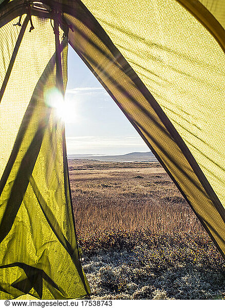 Inside of tent pitched in Hardangervidda National Park with rising sun in background