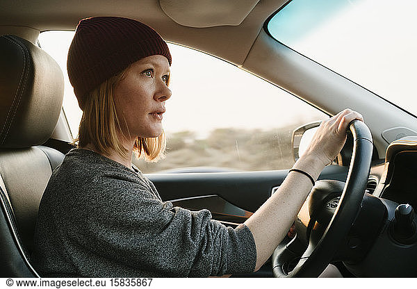 Inside view of woman driving in Big Sur at sunset