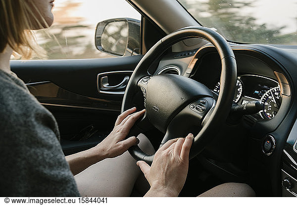 Inside view of woman driving in Big Sur at sunset