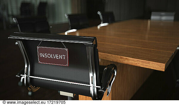 Insolvenzschild auf einem Stuhl am Konferenztisch im Büro