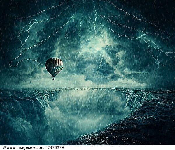 Inspirational imaginary view  scary landscape as a hot air balloon fly over the chasm of a foggy waterfall below a dark stormy sky