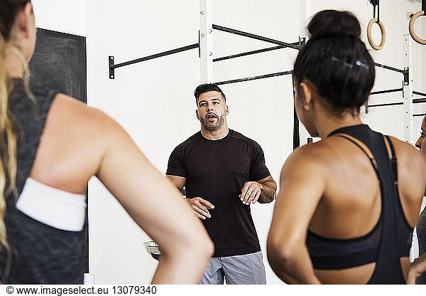 Instructor explaining athletes in crossfit gym