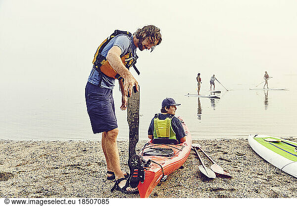 Instructor helps his young student get ready for a kayaking trip