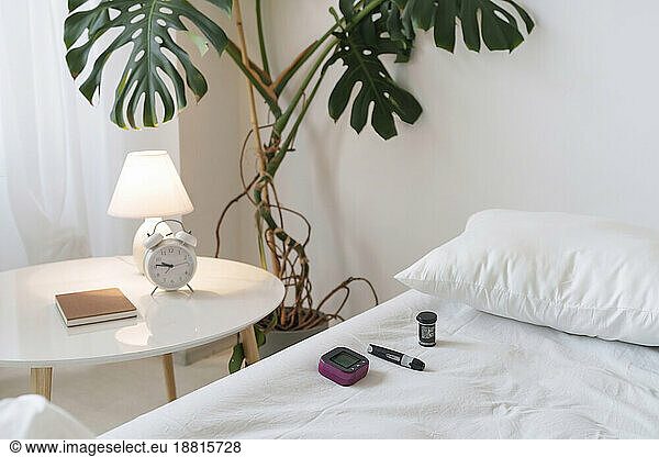 Insulin and glucometer on bed at home
