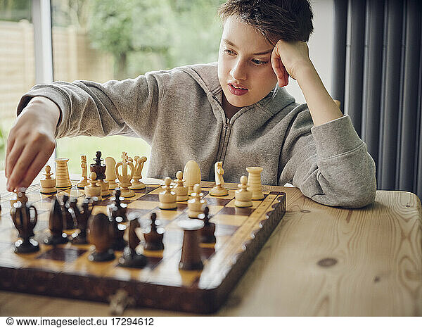 Intelligenter Junge spielt zu Hause Schach