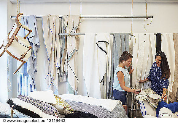 Interior designers selecting curtain samples in workshop