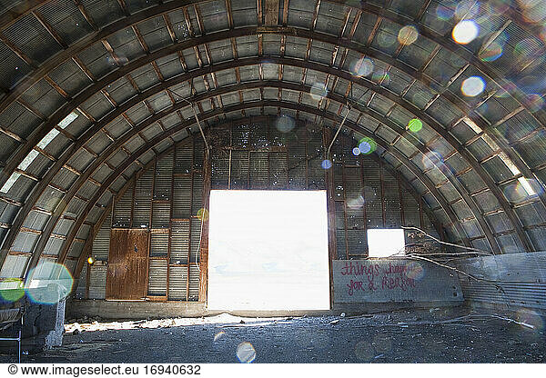 Interior of a deserted building  big open door and arched roof