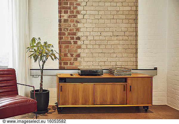 Interior of a loft flat with brick wall and chest of drawers