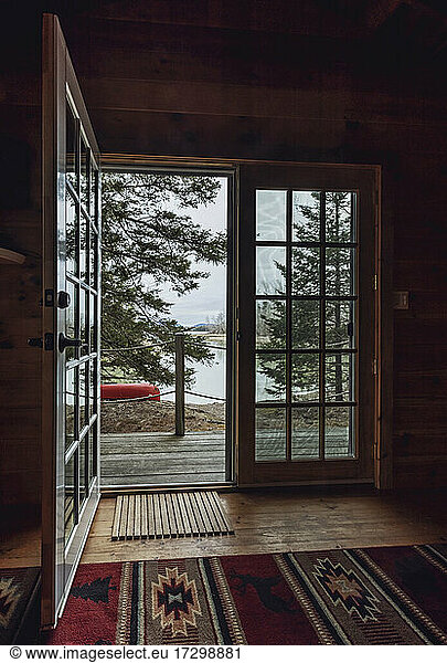 Interior view through open door at woods and water view  coastal Maine