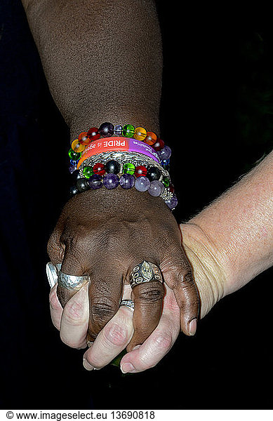 Interracial married lesbian couple holding hands (MR)