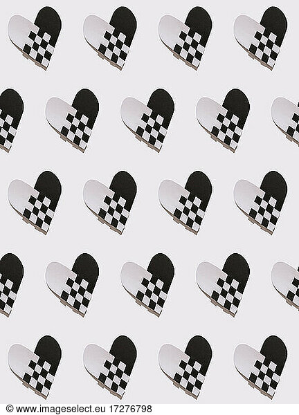 Intertwined black and white paper hearts on white background