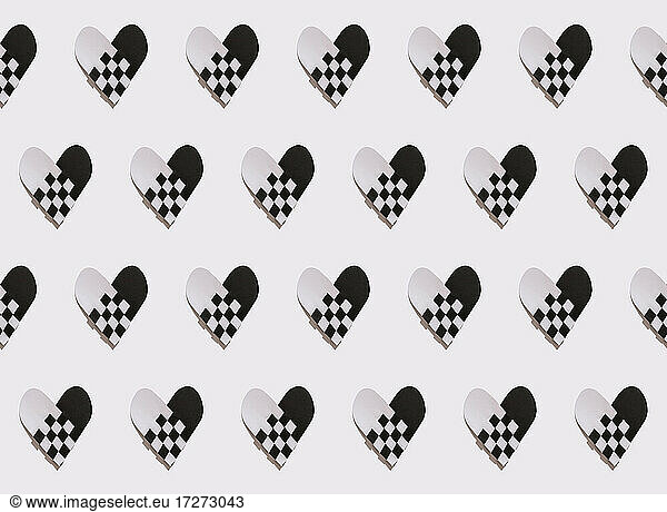 Intertwined hearts of black and white papers on white background