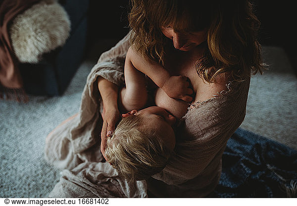 Intimate moment of mum breastfeeding her son showing lots of skin