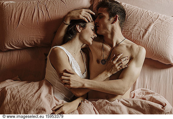 Intimate young couple lying in bed