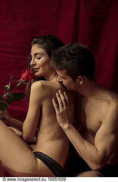 Intimate young couple with red rose