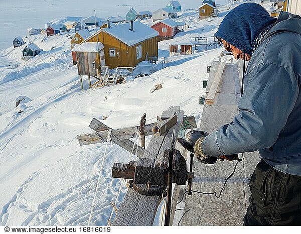 Inuit-Jäger bereitet seine Werkzeuge vor. Das traditionelle und abgelegene grönländische Inuit-Dorf Kullorsuaq  Melville Bay  Teil der Baffin Bay. Amerika  Nordamerika  Grönland  dänisches Gebiet.
