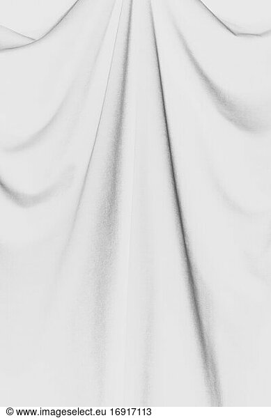 Inverted black and white image of draped velvet curtain