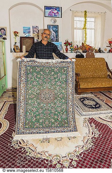Iranischer Mann zeigt einen handgefertigten Teppich  Na?in  Provinz Isfahan  Iran  Asien