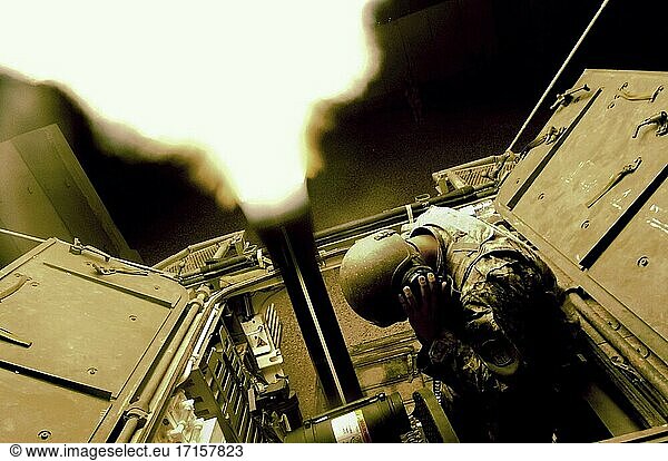 IRAQ Mosul -- 01. Juni 2006 -- Ein Soldat der US-Armee hält sich die Ohren zu  während er mit einer 120-mm-Mörserkanone in einem Mörser-Trägerfahrzeug (Stryker) Beleuchtungsfackeln über der Stadt Mosul im Irak abfeuert. Der Soldat und sein Stryker gehören zum 1st Battalion  17th Infantry Regiment  Mortars. Foto der US Air Force (freigegeben) -- Bild von Jeremy T Lock / Lightroom Photos / USAF.