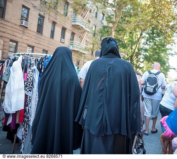 Islamic women in full burqas walk through the Brighton Beach Jubilee in the Brighton Beach neighborhood of Brooklyn in New York The neighborhood is sometimes colloquially named ´´Little Odessa´´ because of its popularity amongst Russian emigres and its proximity to the ocean.