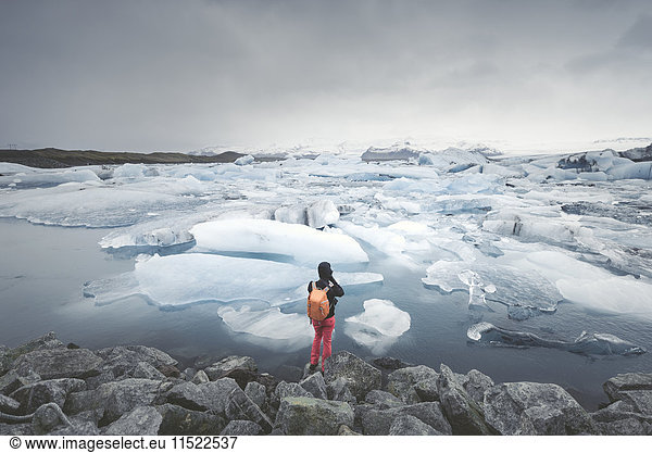 Island  Blick auf Joekulsarlon  Gletscherlagune mit Mann im Vordergrund