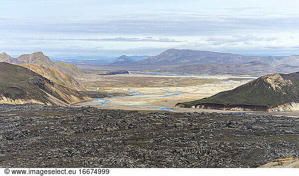 Islands vulkanische schwarze Felslandschaft mit Flüssen und moosbewachsenen Hügeln