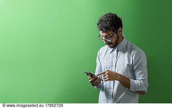 Isolated person checking his cell phone  Teenage guy checking his cell phone isolated  View of handsome man using a cell phone isolated