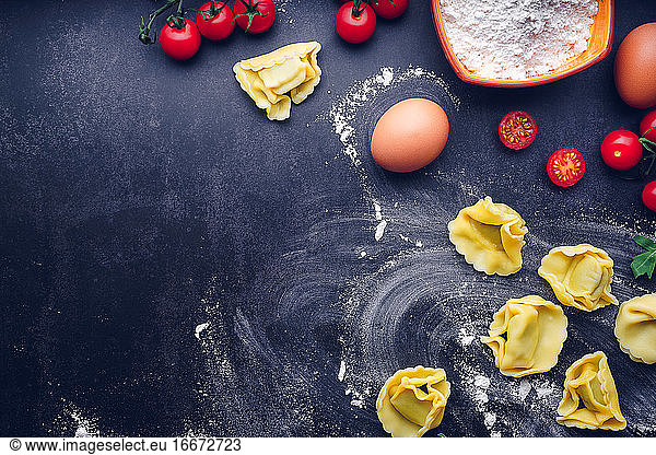 Italian pasta with ingredients and black background. Gastronomic concept