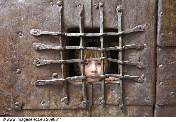 Italien  Südtirol  Portrait eines Mädchens hinter Gittern