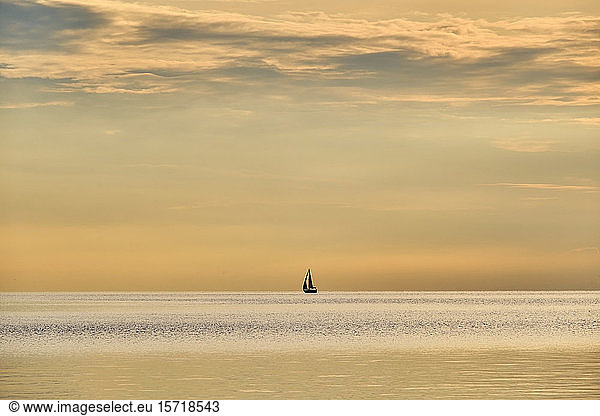 Italy, Trentino, Nago-Torbole, Silhouette of sailboat sailing across Lake Garda at moody dawn, Italy, Trentino, Nago-Torbole, Silhouette of sailboat sailing across Lake Garda at moody dawn