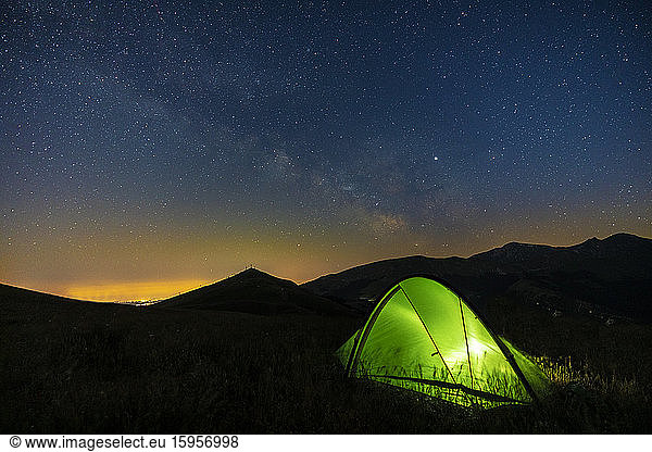 Italy  Green illuminated tent pitched in Piani di Ragnolo plateau at night